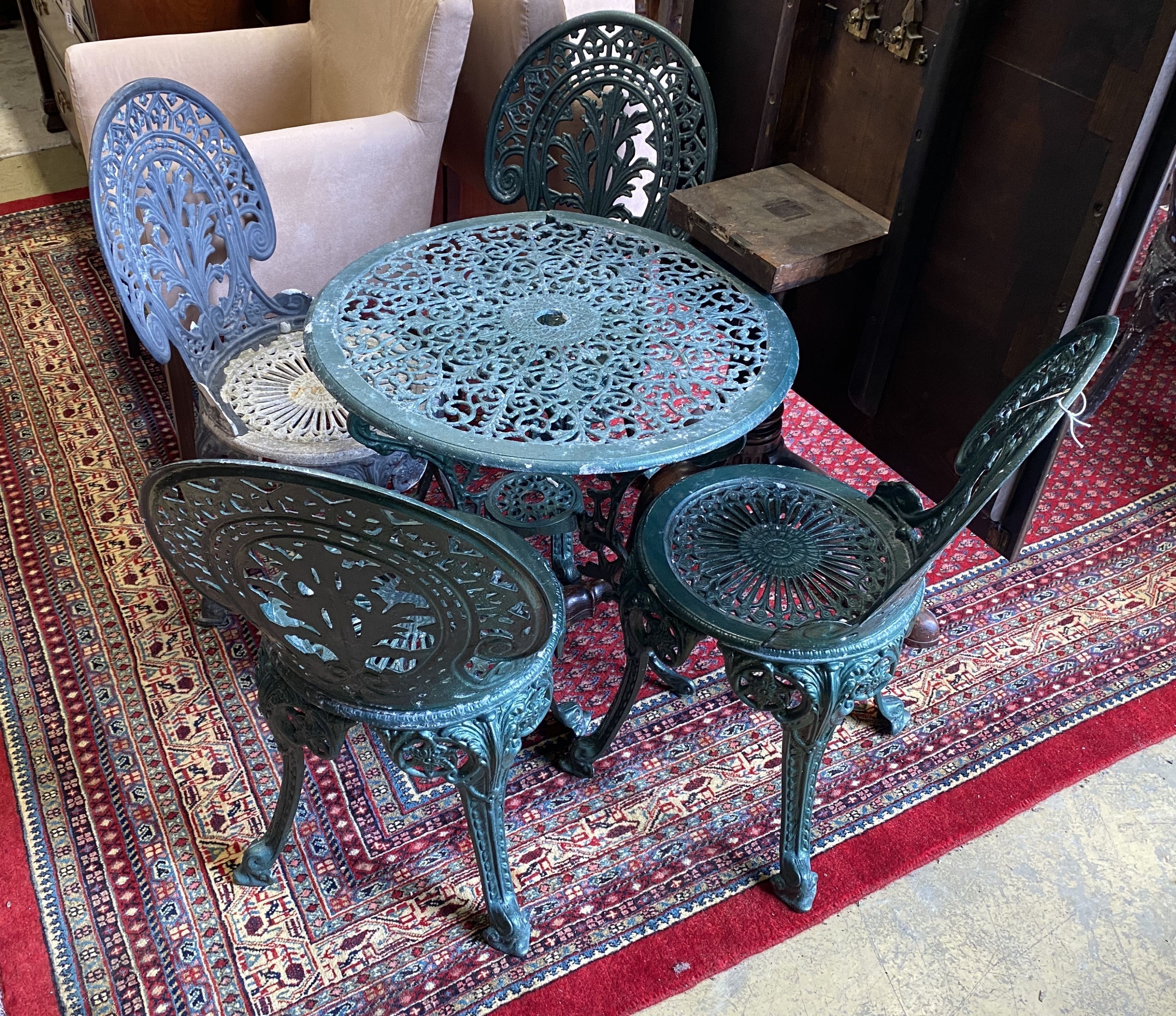 A Victorian style circular painted aluminium garden table, diameter 66cm, height 66cm and four chairs